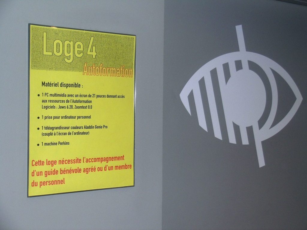Logo déficience visuelle et description sur un panneau du matériel disponible dans une loge de la Bpi.