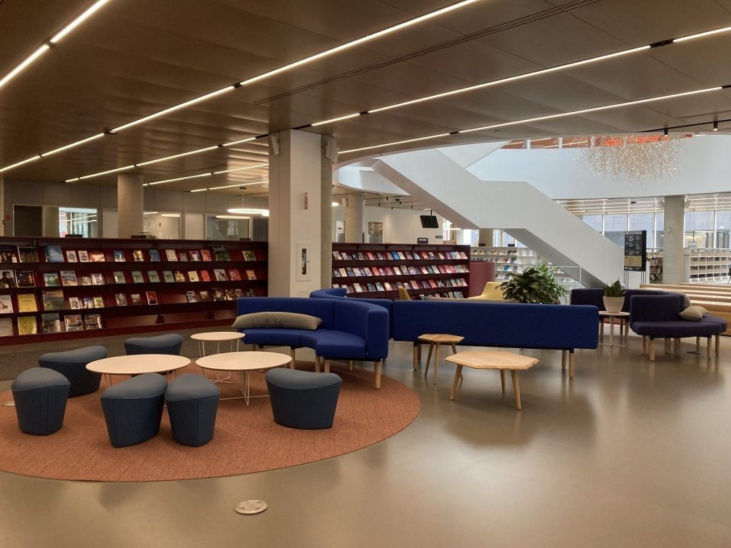 Grand espace de lecture ouvert avec tables basses et assises confortables