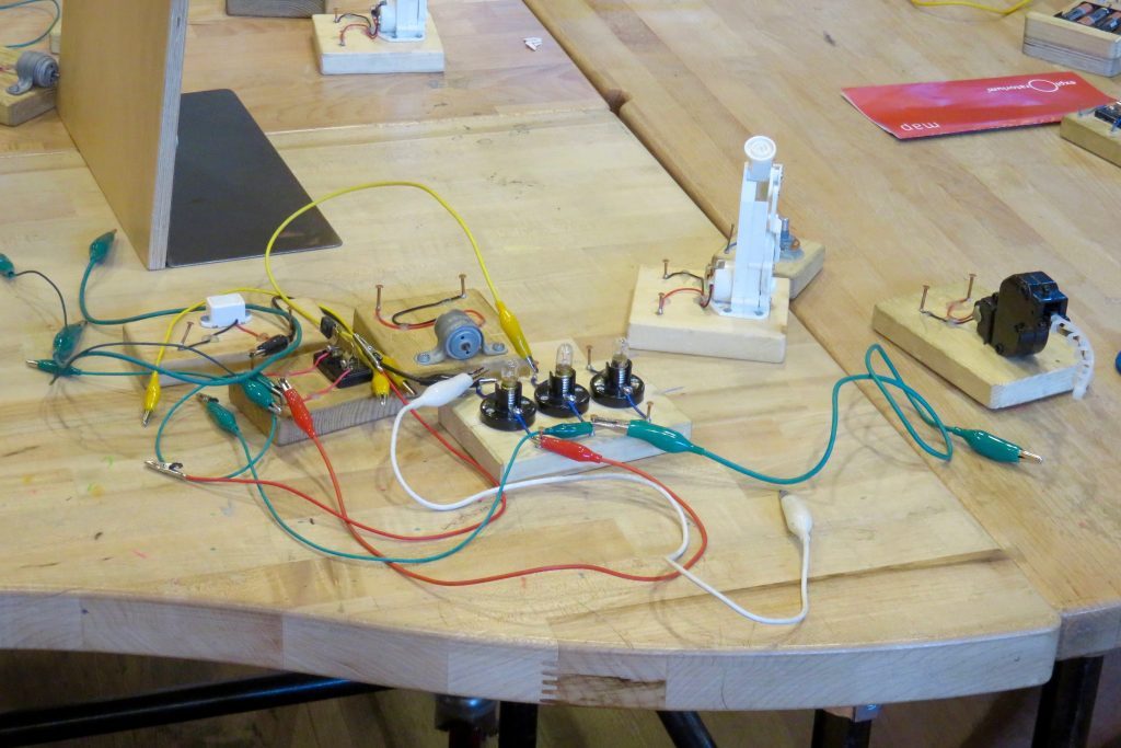 Fils de toutes les couleurs, branchements, petits appareils électriques posés sur une table