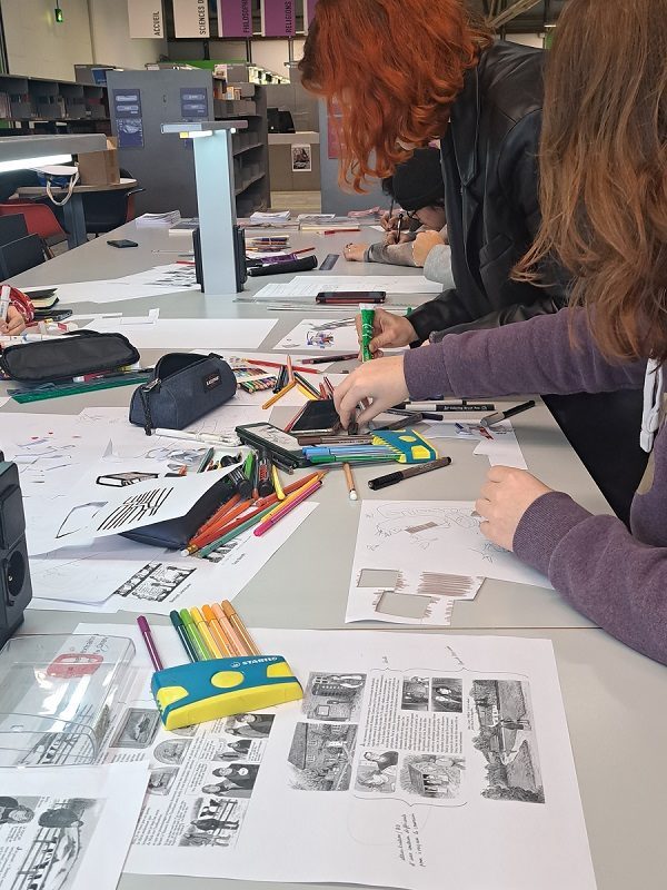 Des étudiants font des découpages, collages et dessins à une table dans le cadre d'un atelier créatif