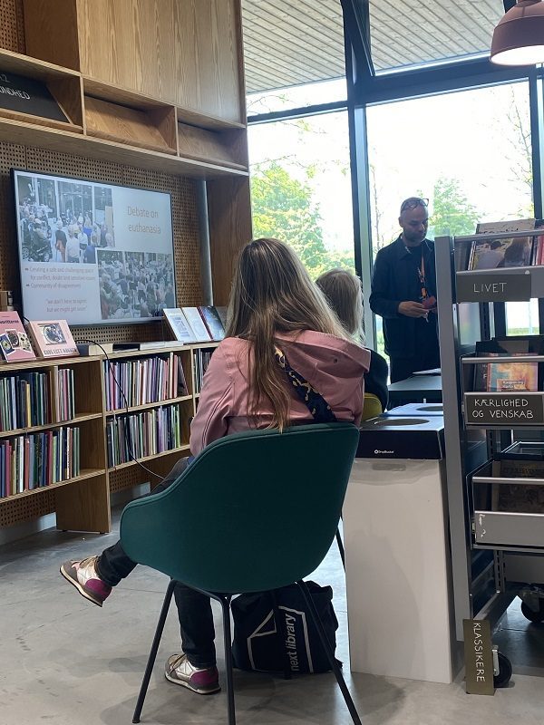 Un homme présente un powerpoint devantun groupe de bibliothécaires