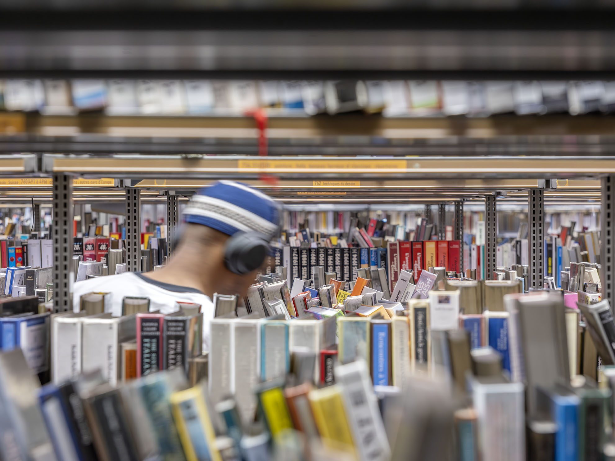 Personne recherchant un livre dans les rayonnages de la Bpi © Luc Boegly