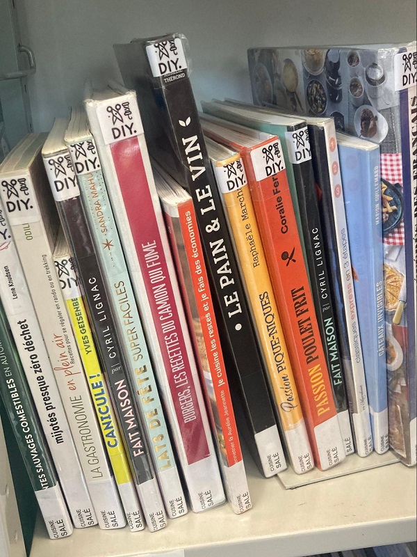 Rayonnage de livres de cuisine rangés verticalement. Les étiquettes de cote au bas des livres indiquent "CUISINE SALÉ" en toutes lettres, illustrant le système de cotation en langage naturel adopté par la Bibliothèque municipale de Lyon. Plusieurs livres portent également un pictogramme "DIY".