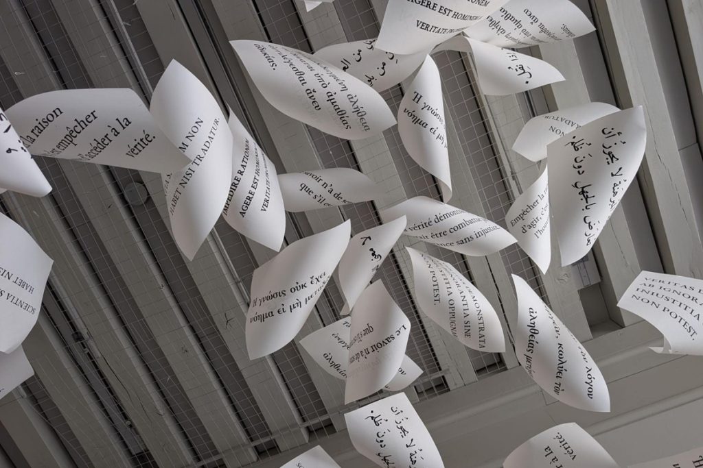 Dizaines de pages pliées en forme de feuilles, portant des citations sur la vérité et la connaissance en plusieurs langues (français, latin, grec, arabe).