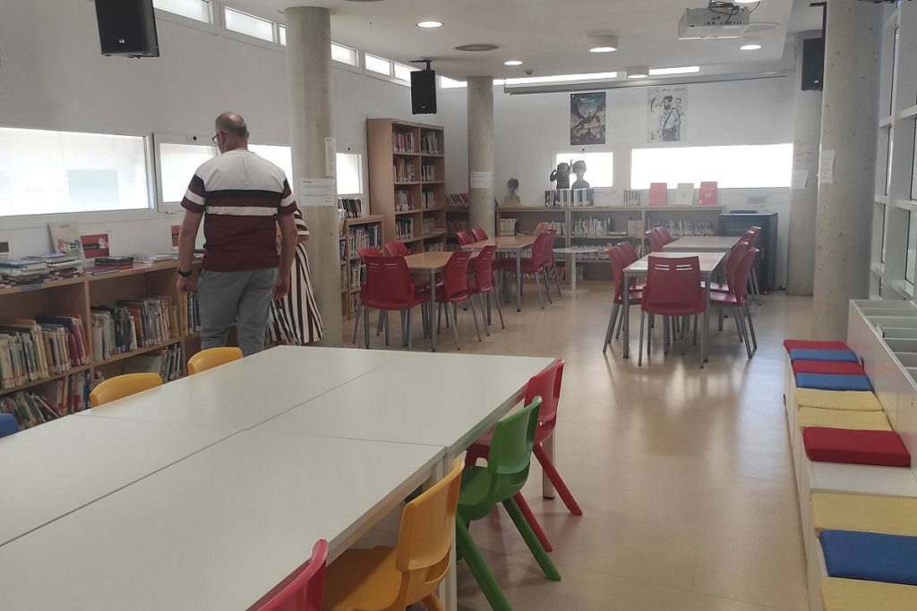 Espace jeunesse réaménagé, avec tables, chaises colorées et coussins au sol, après les travaux de réhabilitation.