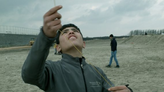 Un garçon jouant au cerf-volant dans la Jungle de Calais