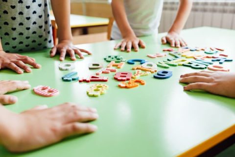 Mains d'enfants déplaçant des lettres sur une table
