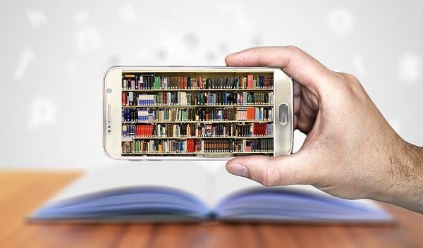 main tenant un smartphone avec une bibliothèque comme fond d'écran