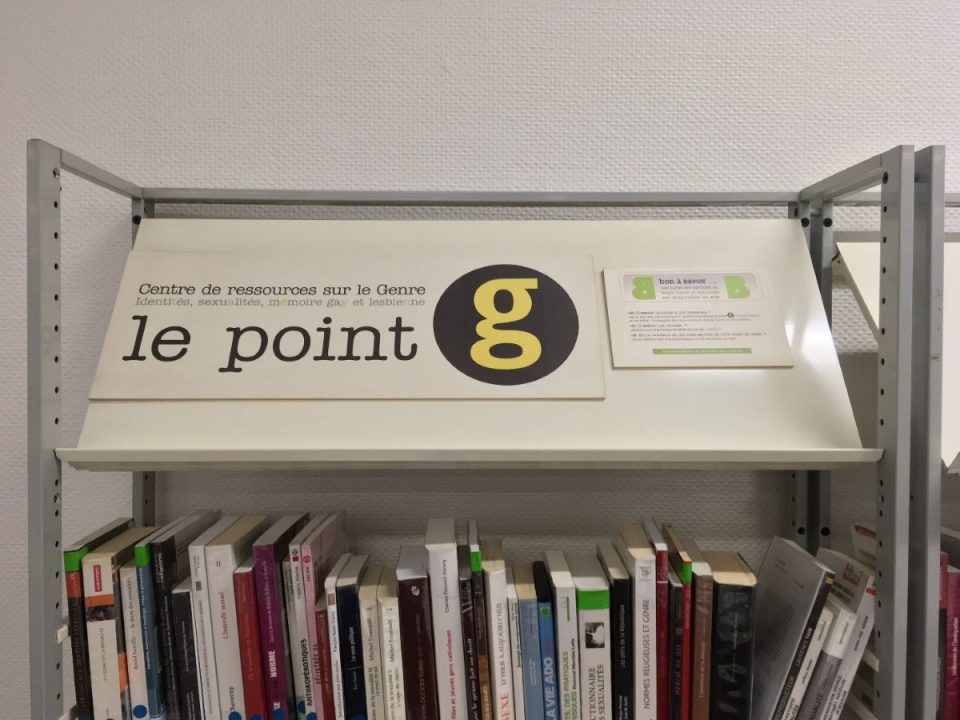 Photographie du logo du point G posé sur une étagère de livres