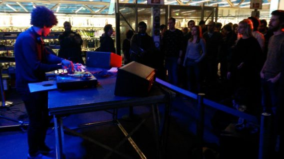 Photographie du concert d'un DJ avec ses platines devant du public