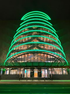 Photographie de la façade du centre des congrès de Dublin éclairé en vert