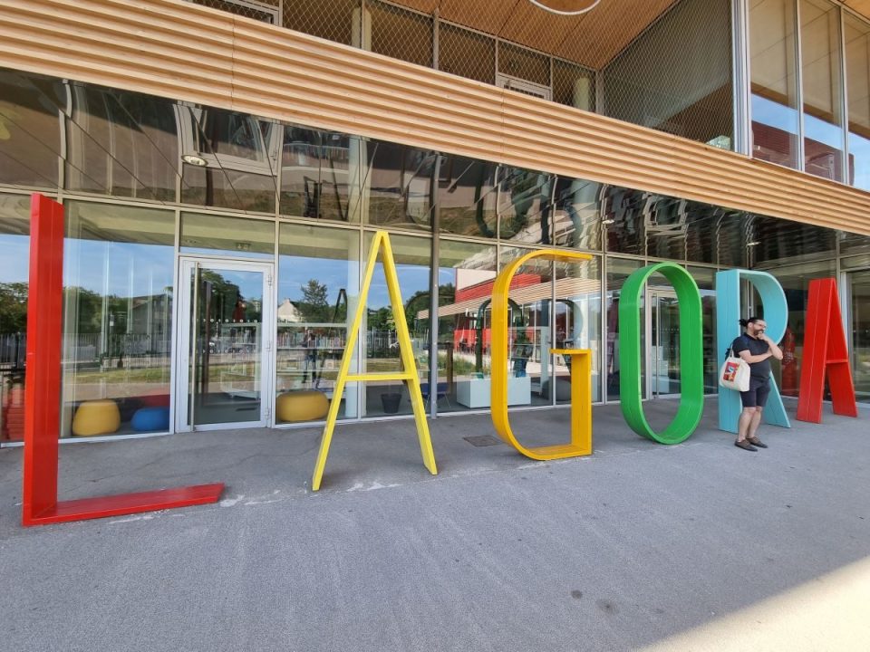 Photographie de l'enseigne de l'Agora formé de lettres à taille humaine présentes devant le bâtiment
