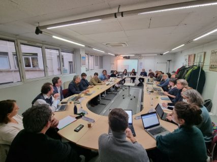 Photographie des membres du Conseil de coopération assis autour d'une grande table ovale
