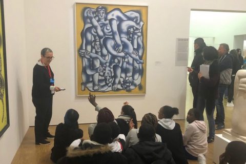 Groupe scolaire assistant à une conférence devant un tableau au Centre Pompidou.