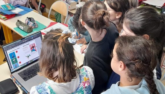Des enfants de dos sont regroupés devant un écran d'ordinateur